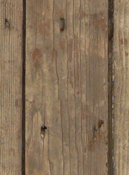 Rustic brown planks with light spots and bent nails covered in rust.